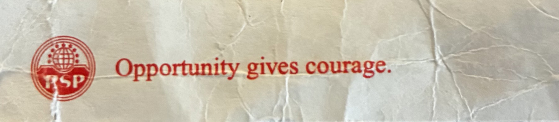 A crumpled paper fragment with a red mark and the text opportunity gives courage